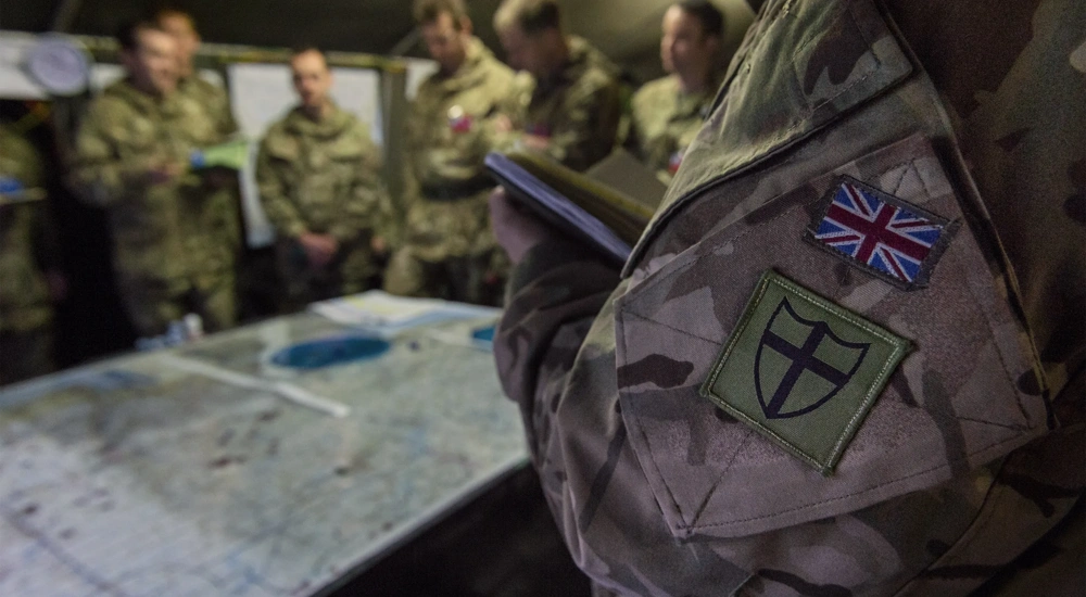 Close up of British Army camouflage uniform with the Union Jack flag sewn on the pocket.