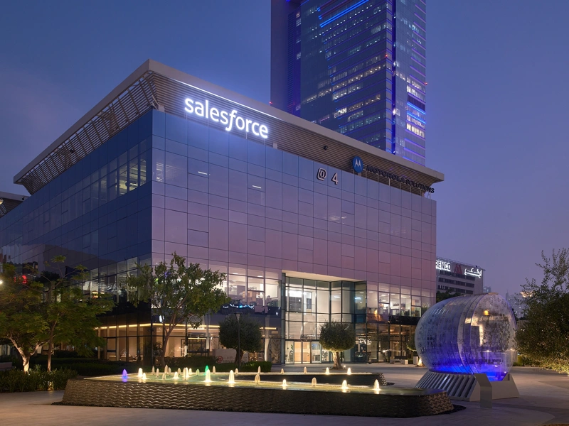 Image of Dubai Salesforce office at night, glass windows that reflects the purple ambiance of the night sky.