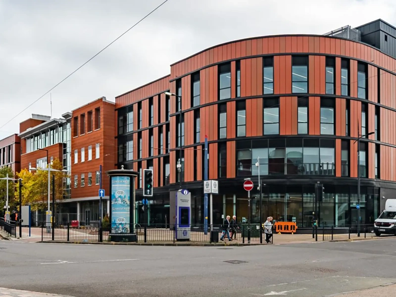 Modern multi-storey office building on city street corner.