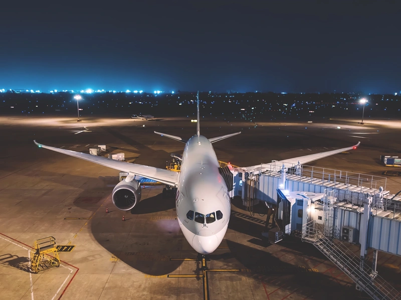 An aeroplane on a tarmac at night
