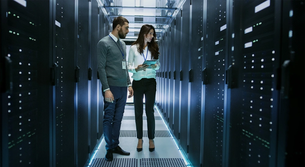 Two employees inspecitng hardware inside a data centre, Colombia