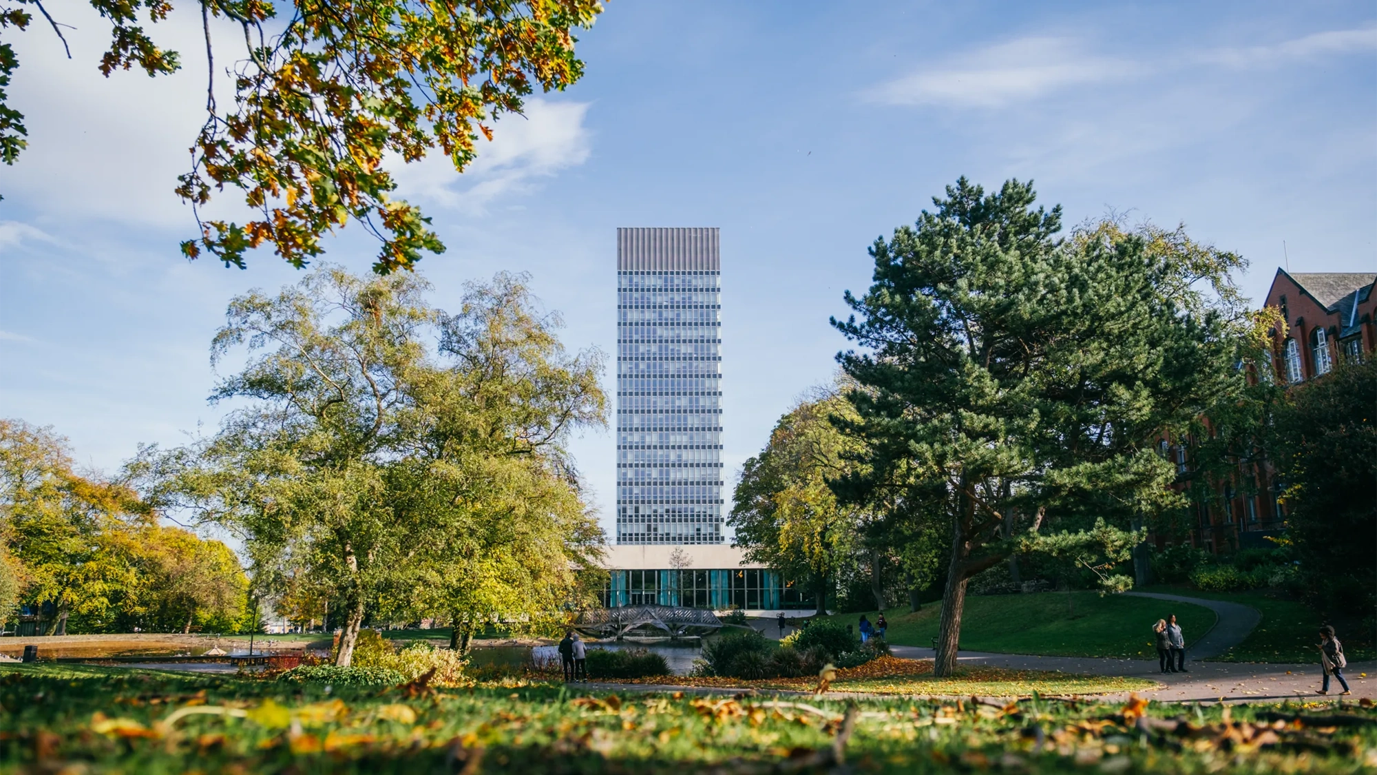 University campus with trees and a tall modern building in background