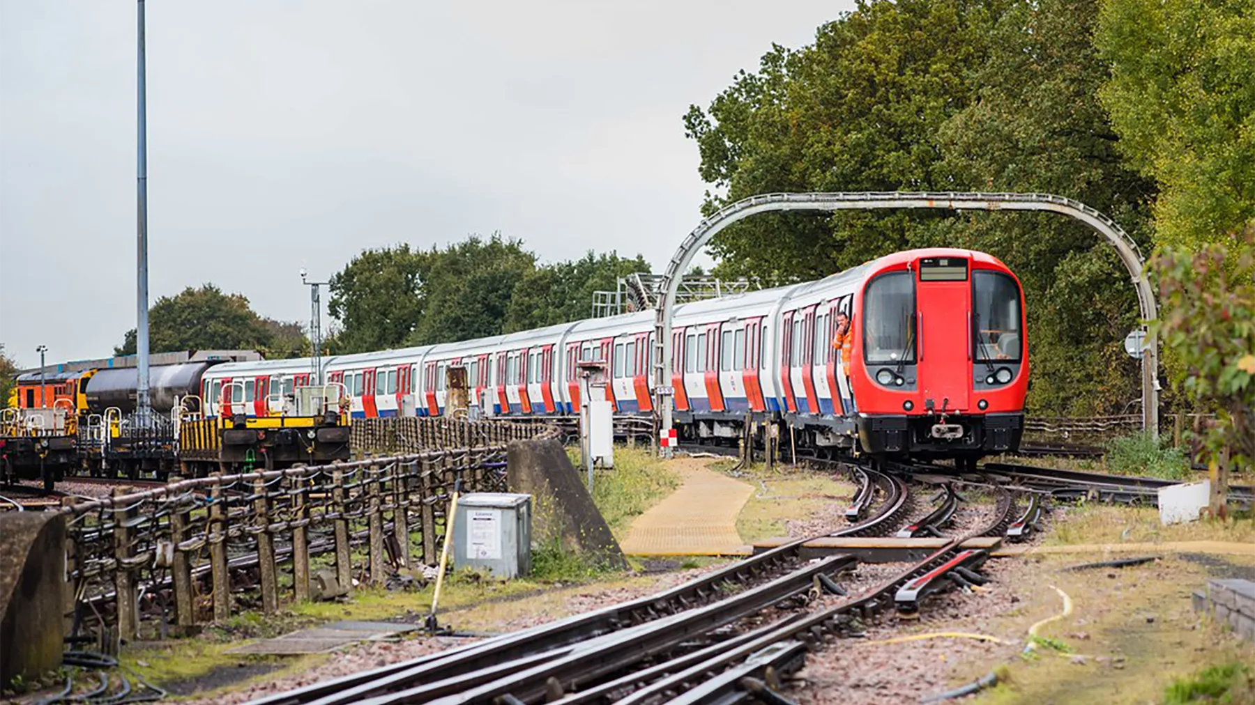 Driverless train approaching station in london's docklands area on a sunny day.