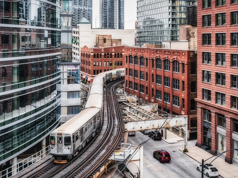 A train moving on tracks in between buildings in Chicago
