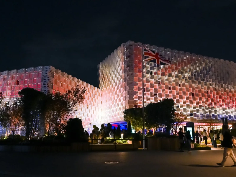 UK Pavilion at night, Expo 2025 Osaka, illuminated with UK flag lights.