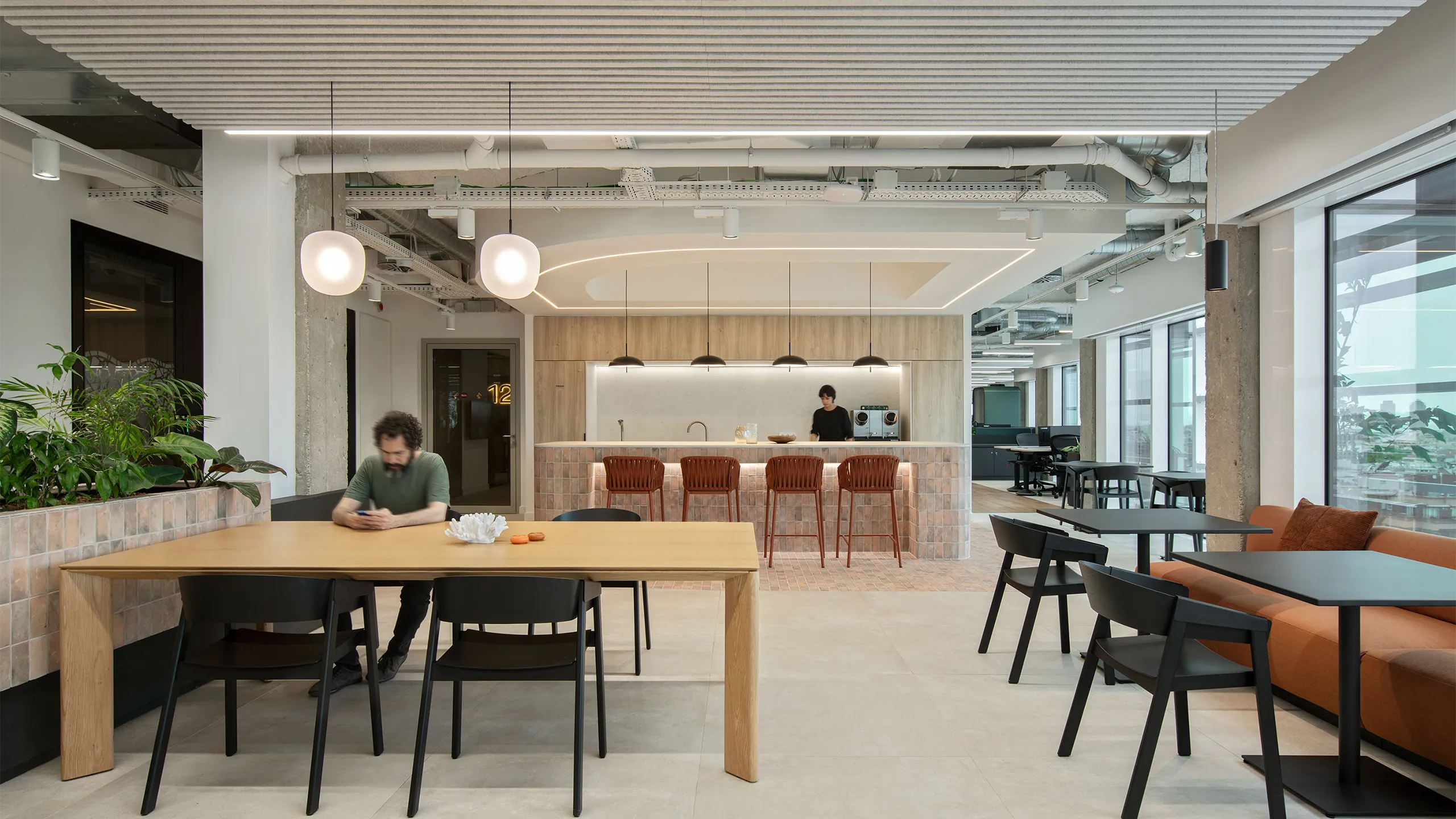 Modern office breakout area with tables, seating and a cafe style counter