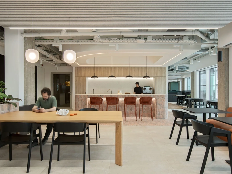 Modern office breakout area with tables, seating and a cafe-style counter