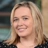 Wendy Cerutti, Head of Cost Management, Johannesburg, outside in front of a blurred brown background featuring a building and mix of natural and urban elements.