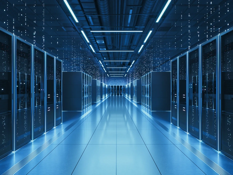 Interior view of a futuristic data center designed for artificial intelligence processing, featuring glowing servers and digital data streams.