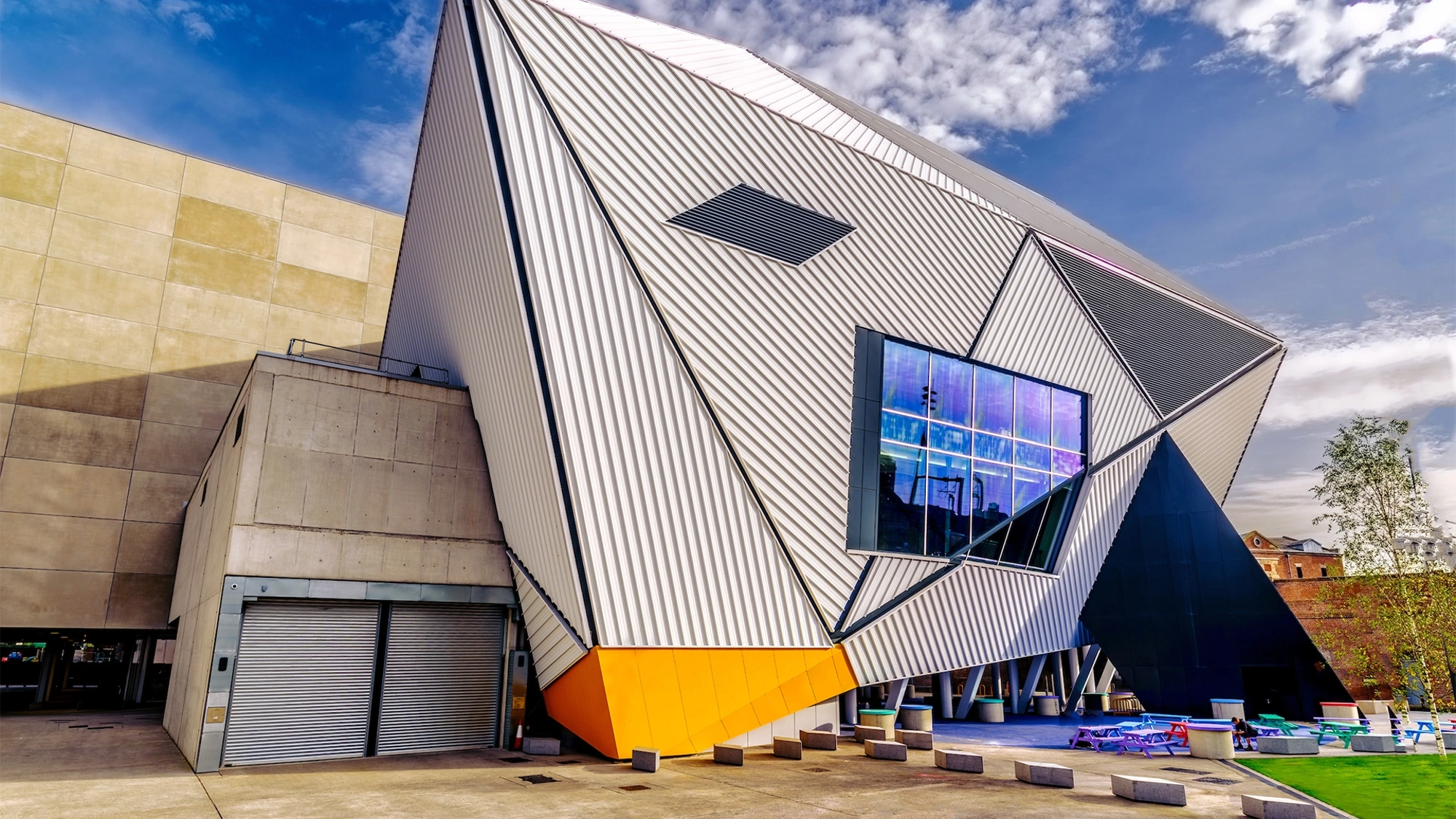 Modern, corrugated building of dynamic angles against a blue sky