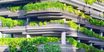 Grey building with green plants on exterior. 
