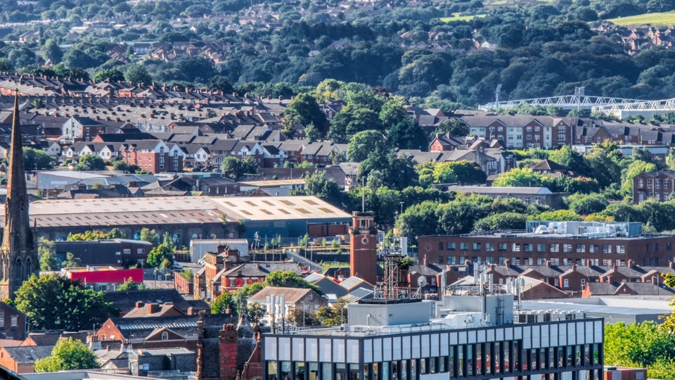 View of Darwen town centre, with buildings in the foreground and trees in the background