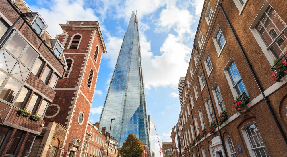 Street level view of the Shard with red brick buildings in the foreground, London, UK