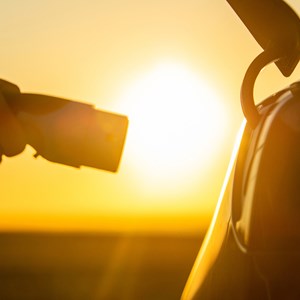 Electric vehicle charging against sunset