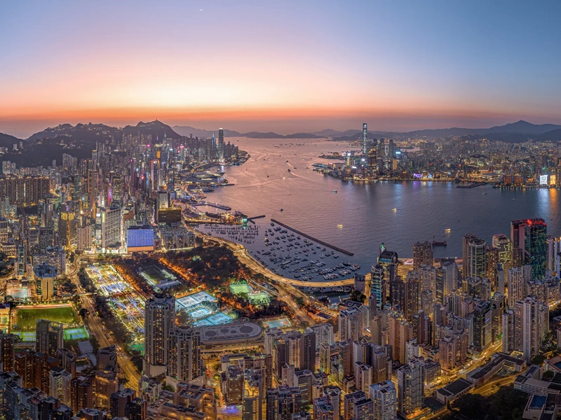 Aerial Drone of Hong Kong island cityscape skyline at night. Skyscraper building in financial, business district and urban lights reflecting on Victoria harbour