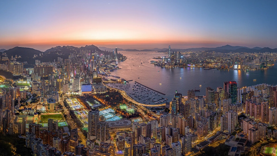 Aerial Drone of Hong Kong island cityscape skyline at night. Skyscraper building in financial, business district and urban lights reflecting on Victoria harbour