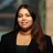 Portrait of Dionne Pereira, Senior Sustainability Consultant, outside in front of a blurred brown background featuring a building and mix of natural and urban elements.