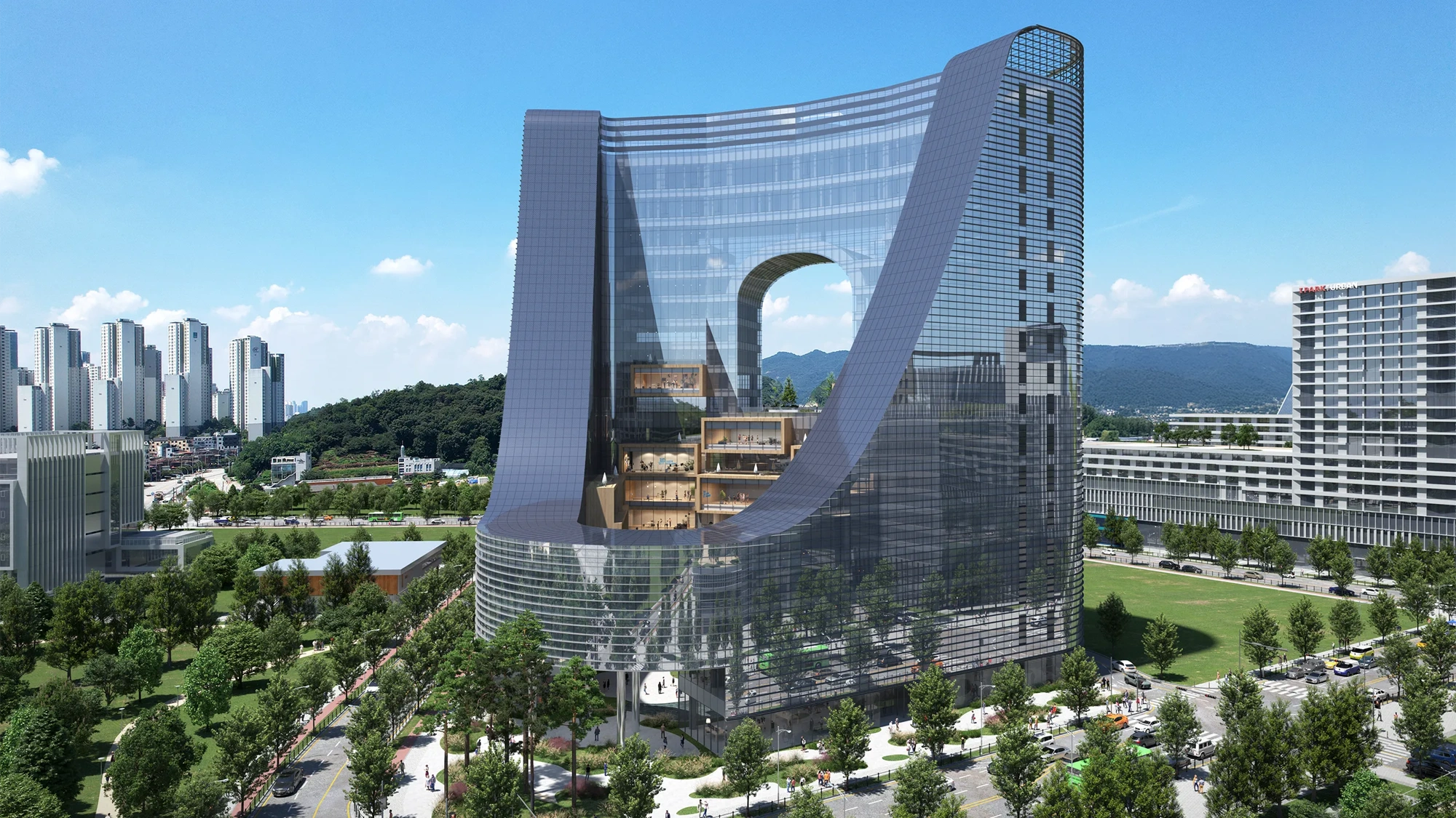 Modern curved glass building with a large central arch, surrounded by greenary and nearby city buildings.