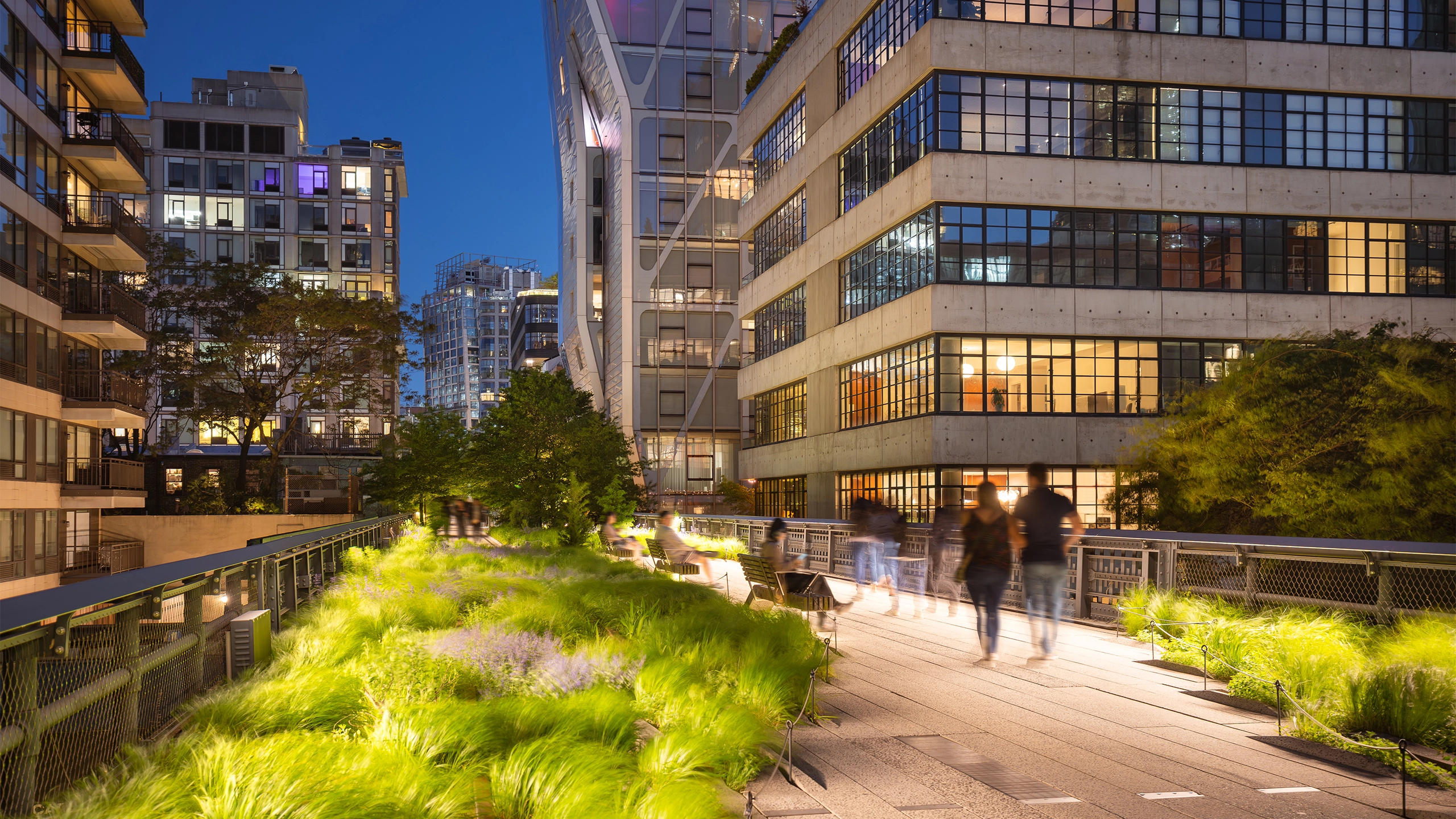 View of buildings late in the evening with pedestrians walking through city