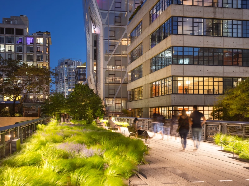 View of buildings late in the evening with pedestrians walking through city