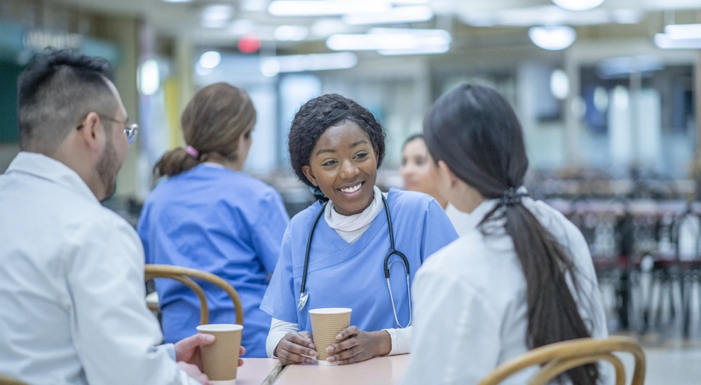 Medical professionals sitting at a table drinking hot beverages