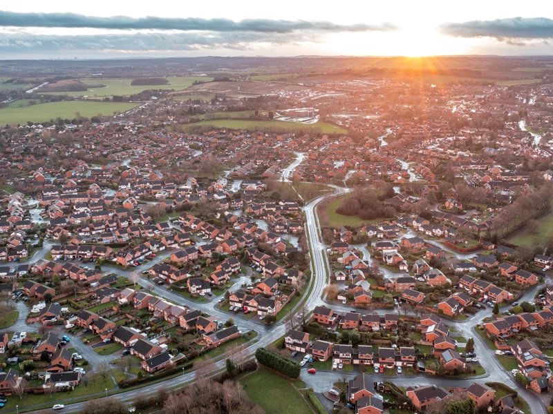 Aerial view of city at sunset in England - New estate with typical British houses and green gardens - Real estate and buildings concepts in UK