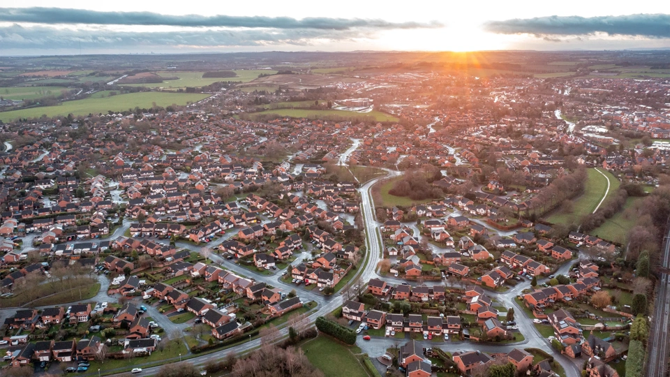 Aerial view of city at sunset in England - New estate with typical British houses and green gardens - Real estate and buildings concepts in UK