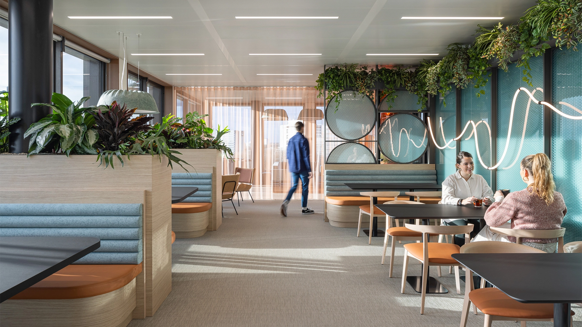 A group of people in a modern office furnished with plants and colourful furniture