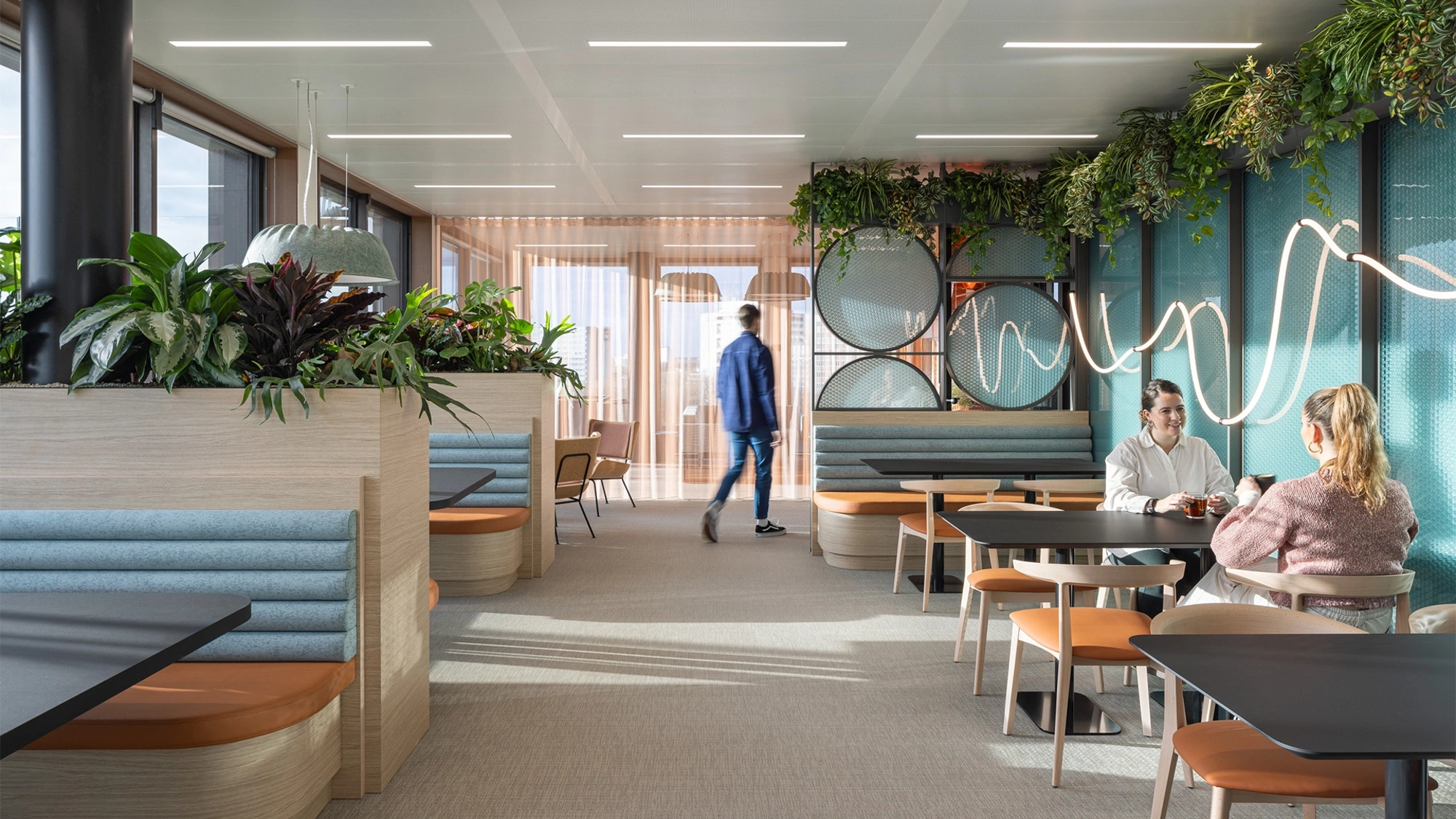 A group of people in a modern office furnished with plants and colourful furniture