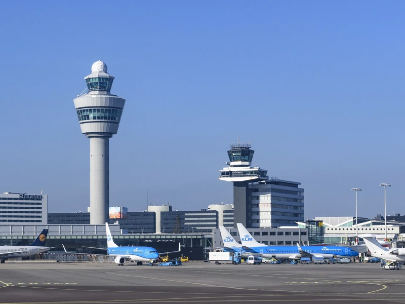 Airplanes at Amsterdam Schiphol Airport in The Netherlands during a springtime sunset.