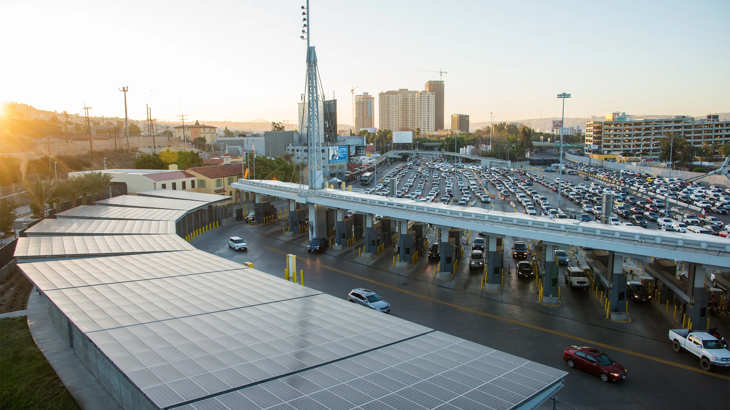 Solar panel roofing before a toll booth where cars are exiting a multi-lane road