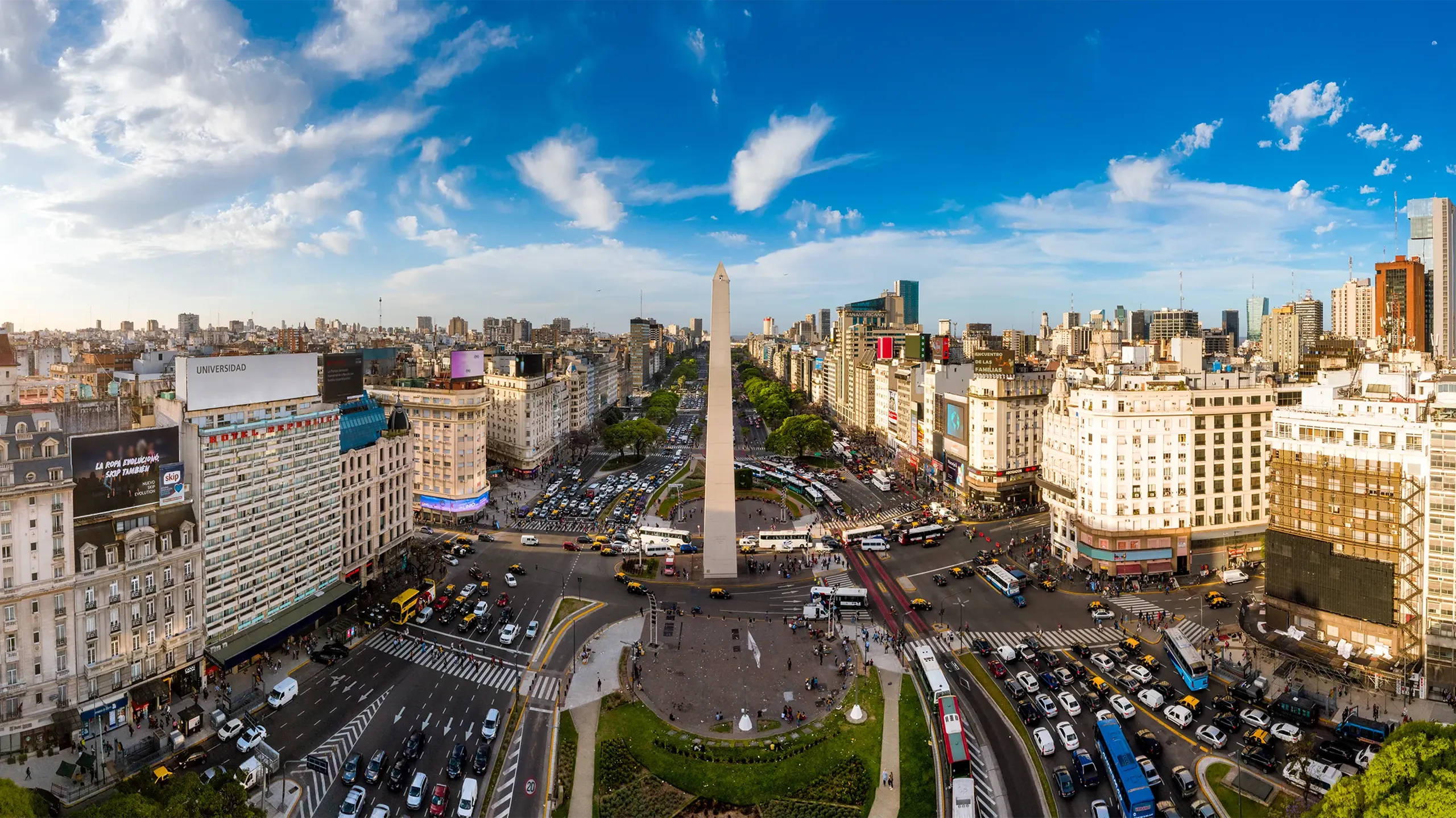 Skyline view of Buenos Aires with lots of cars on the road and tall monument in the middle 