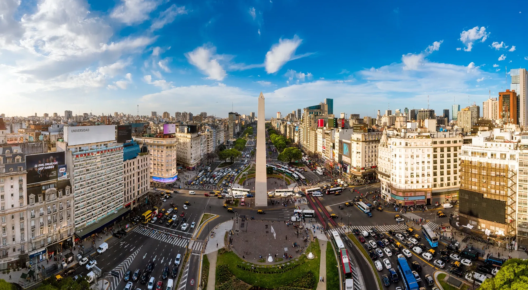 Skyline view of Buenos Aires with lots of cars on the road and tall monument in the middle