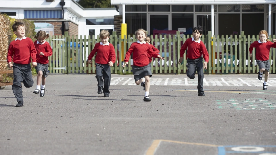 Primary School Pupils Running In Playground Towards Camera