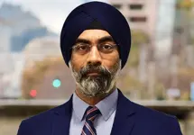 Portrait of Gurjot Bhatia, Managing director, South Asia, Standing outside featuring an urban cityscape with tall buildings and a mix of architectural styles. The scene includes some trees with autumn foliage, adding a touch of color. 