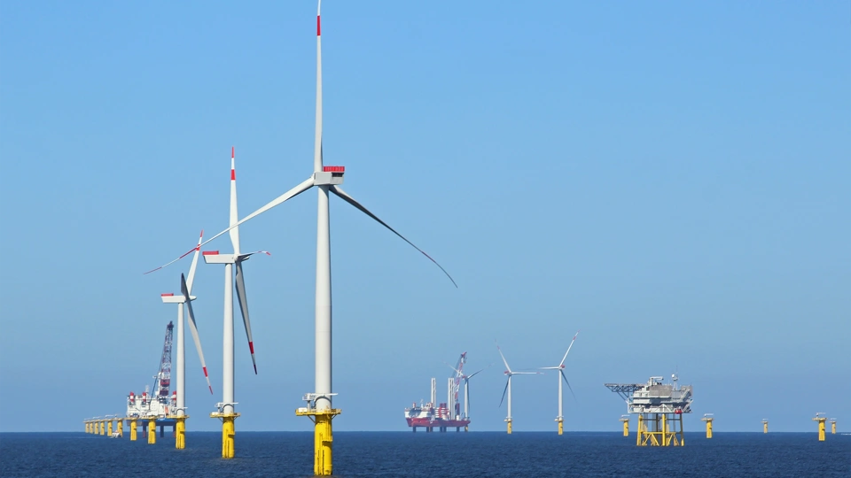 Multiple offshore wine turbines; daytime