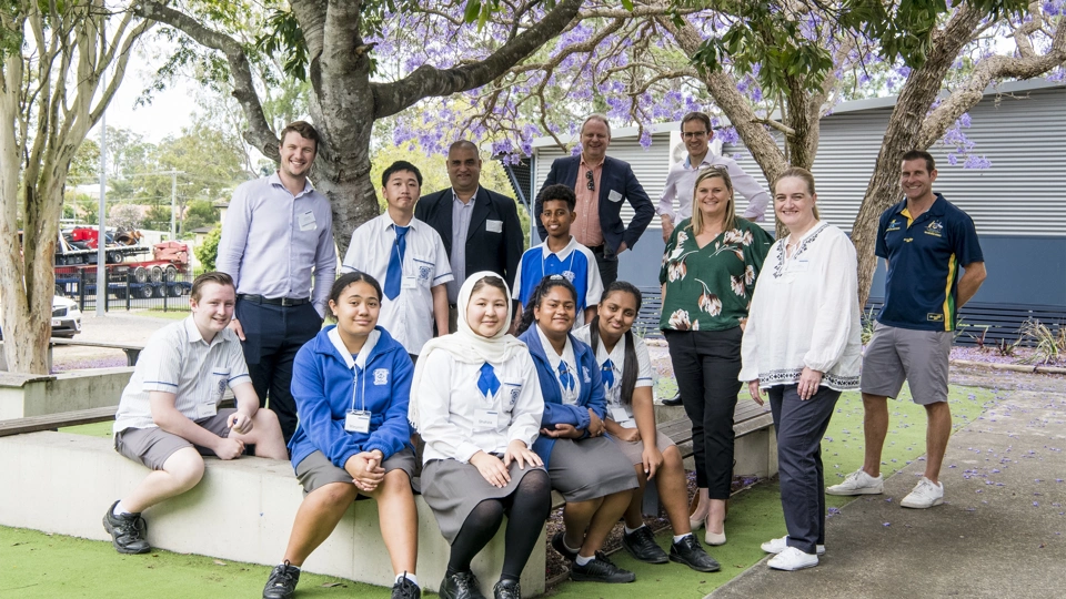 Group of school children and teachers surrounded by trees