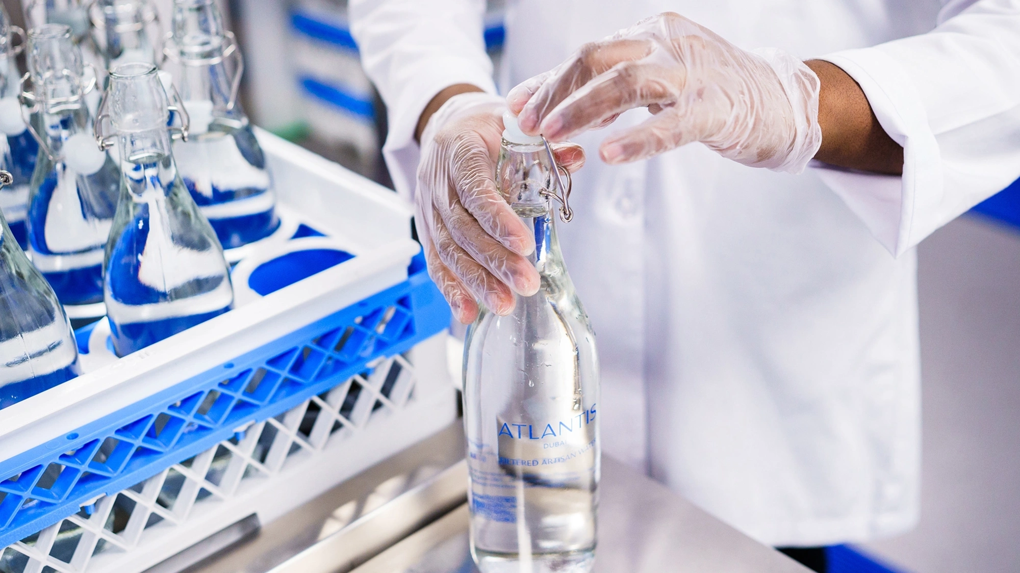 Worker in white lab coat bottling water at the Atlantis, The Palm water purification plant, UAE