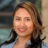 Portrait of Mireille Thakoersingh, Marketing and Communications Manager, outside in front of a blurred brown background featuring a building and mix of natural and urban elements.