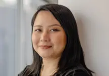 Portrait of Siti Norman, Director, Digital, Singapore, standing against white background and window.