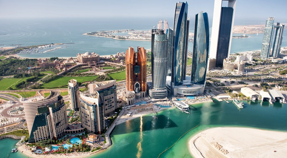 Part of Abu Dhabi, UAE with tall buildings and surrounding area viewed from the helicopter. Many details are visible in the image.