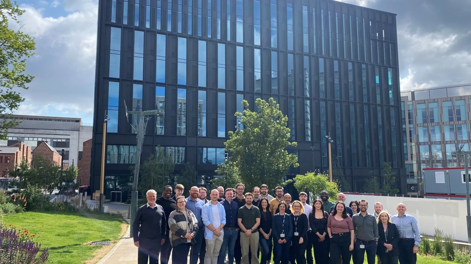 Turner and Townsend Sheffield colleagues standing outside new black window orientated office.
