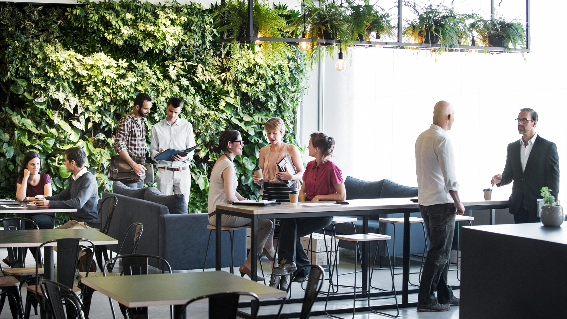 People in group standing in front of living wall