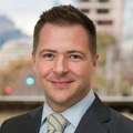 Gareth Whisson, Managing Director, Latin America, standing outside featuring an urban cityscape with tall buildings and a mix of architectural styles. The scene includes some trees with autumn foliage, adding a touch of color.
