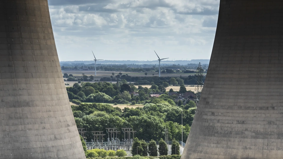 a close up view of the cooling towers at Drax power station showing a wind farm in the distance