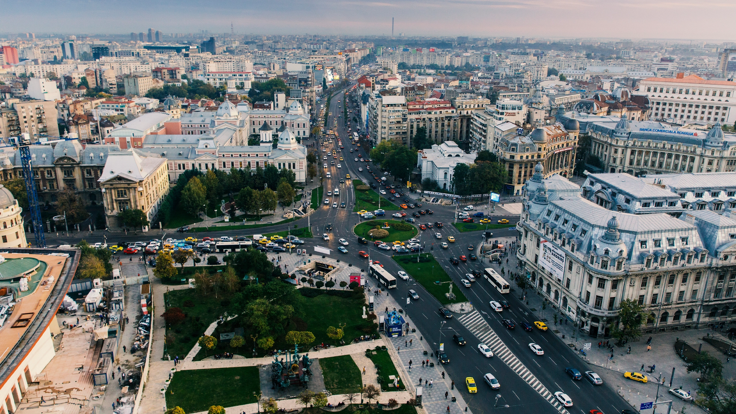 Aerial view of a busy city intersection with historic buildings, multiple roads and heavy traffic.
