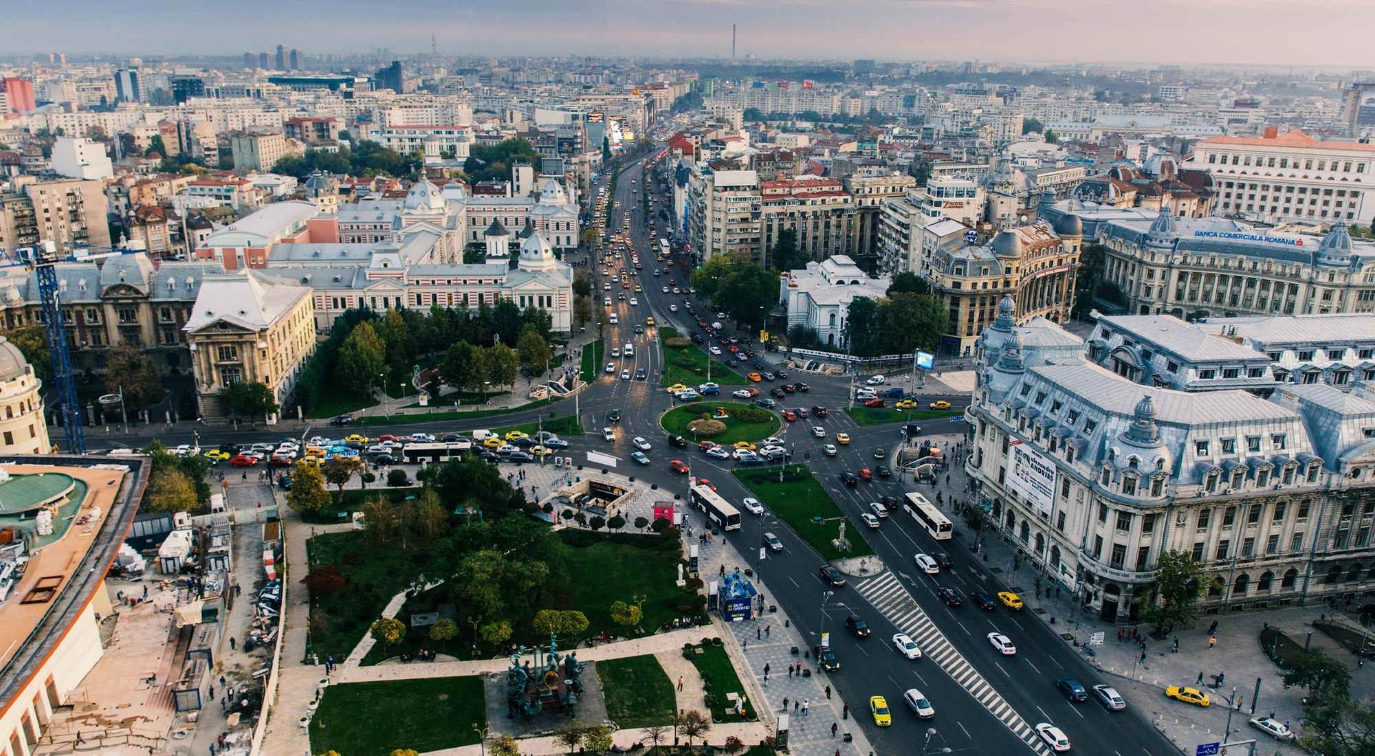Aerial view of a busy city intersection with historic buildings, multiple roads and heavy traffic.