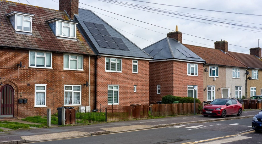 Brown houses on street with two houses that have solar panels on roof
