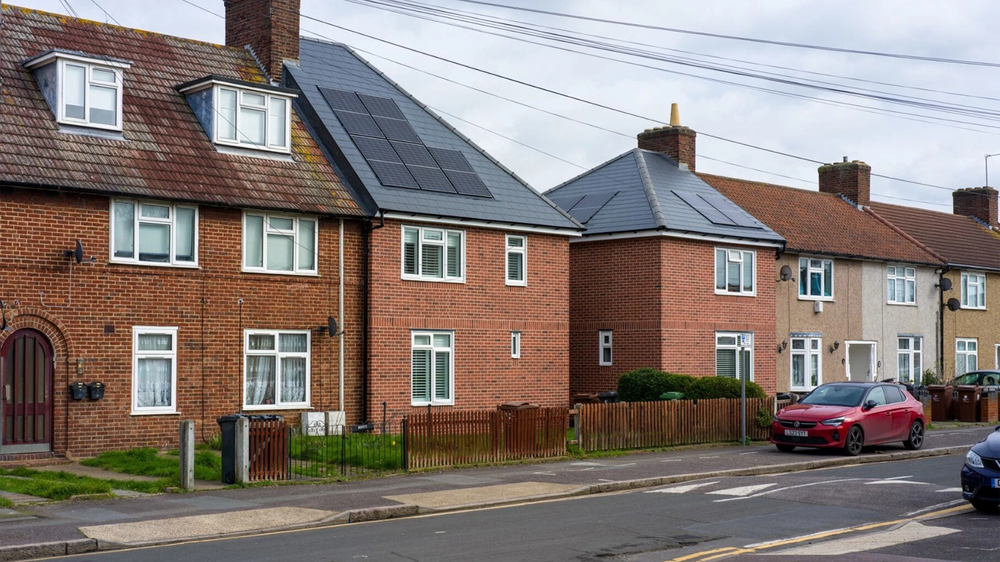 Brown houses on street with two houses that have solar panels on roof