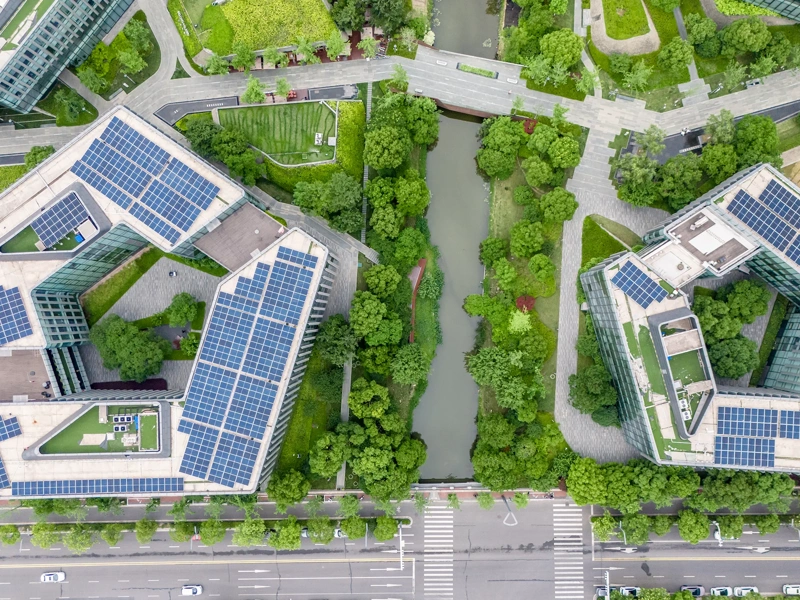 Aerial Top view of green rooftop architecture in eco-conscious cityscape, showing sustainable skyscrapers with trees, landscaped terraces, and climate-focused design promoting CO2 reduction and ESG goals.